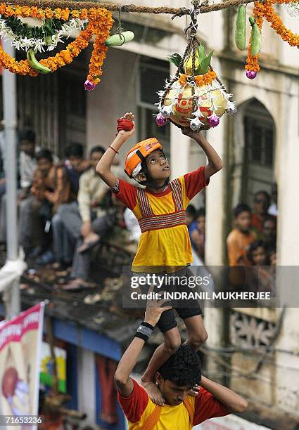 Boy standing on top of a human pyramid prepares to break a "dahi-handi" in Mumbai, 16 August 2006 on 'Janmashtami' which marks the birth of Hindu God...