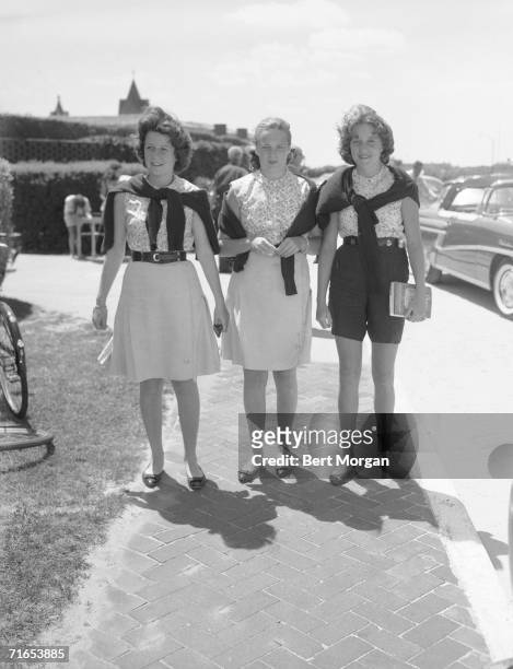American socialites Anne Ford, Charlotte Ford, daughters of Henry Ford II, and lee Auchincloss arrive dressed very similarly at the Southampton...