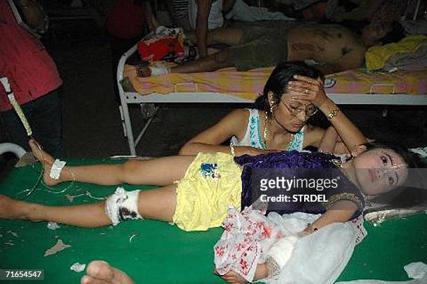 Survivor of a powerful bomb blast in a crowded Hindu temple is watched over in Imphal, capital of the north-eastern state of Manipur, 16 August 2006....