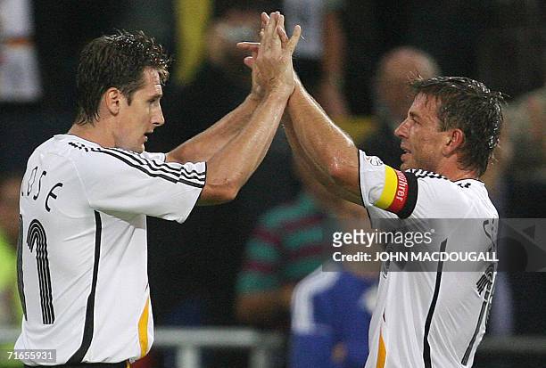 Gelsenkirchen, GERMANY: German forward Miroslav Klose celebrates with German midfielder Bernd Schneider after Klose scored his team's third goal...