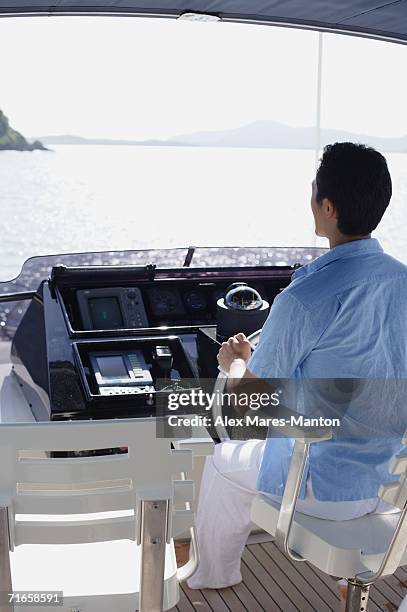 man steering yacht, rear view - driving barefoot stock pictures, royalty-free photos & images