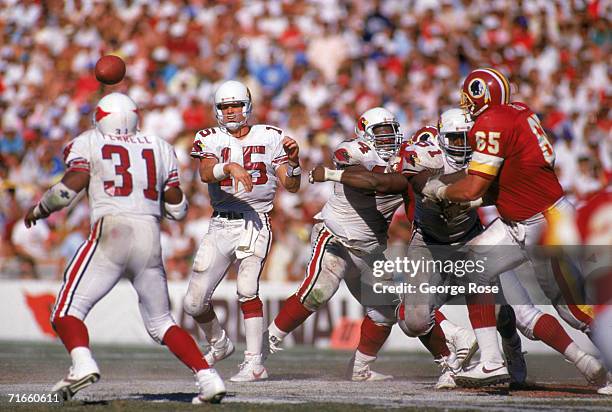 Quarterback Neil Lomax of the Phoenix Cardinals throws a short pass to running back Earl Ferrell during a game against the Washington Redskins at Sun...
