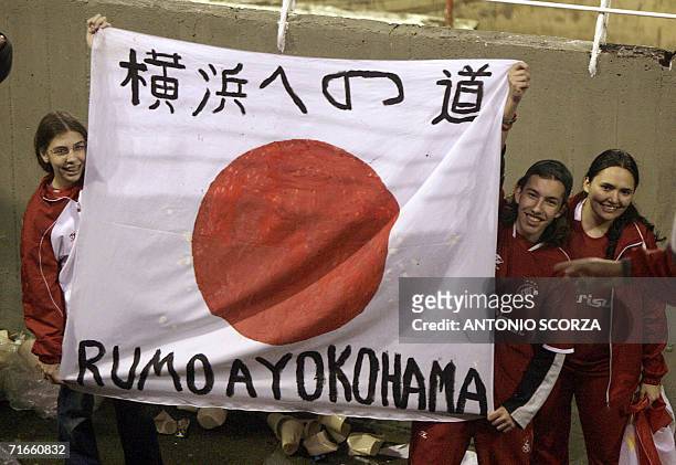 Internacional's supporters hold a Japanese flag with inscriptions that reads in Portuguese and Japanese "On the way to Yokohama" while celebratring...