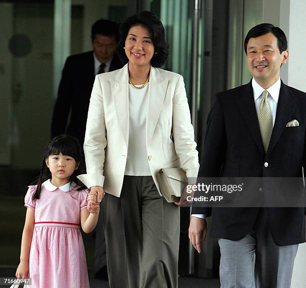 Japanese Crown Prince Naruhito and Princess Masako accompanied by their daughter Princess Aiko walk to their plane at the new Tokyo International...