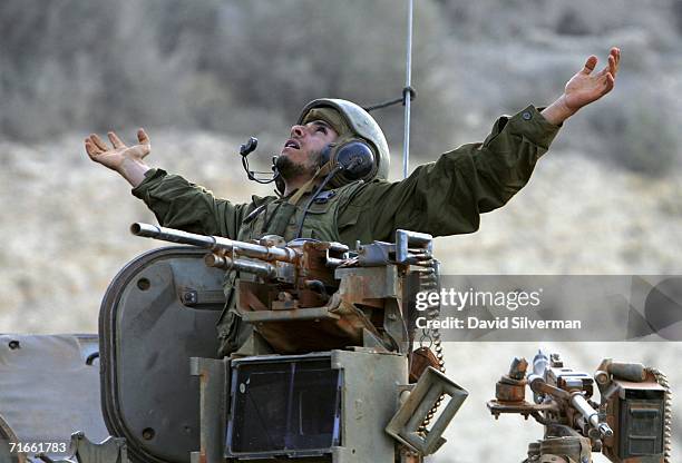 An Israeli soldier stretches as he prepares to disembark from an armored personnel carrier on his return from an early morning patrol in southern...