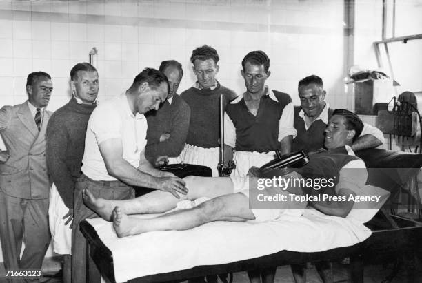 Arsenal trainer Tom Whittaker treating Alfred Kirchen with a short wave diathermy machine in the changing room at the Arsenal Stadium, Highbury,...