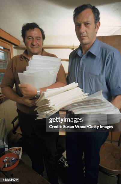 American authors and hoax perpetrators Clifford Irving and Richard Suskind hold stacks of paper inside a house, 1972. The two writers were convicted...