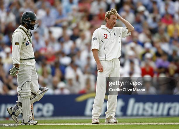 Paul Collingwood of England scratches his head as Mohammad Yousuf of Pakistan looks on during day two of the fourth npower test match between England...