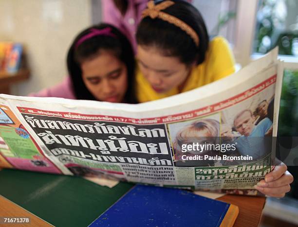 Thai receptionist reads the local newspaper at the Blooms apartment building on August 18, 2006 in Bangkok, Thailand. American John Mark Karr lived...