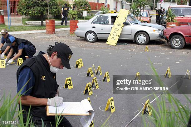 Agentes del Ministerio Publico trabajan junto a un vehiculo turismo en cuyo interior fue asesinada una octogenaria junto a su hija, en la zona 8 de...