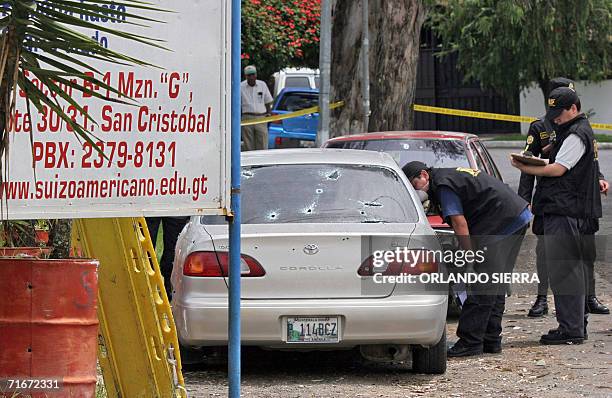 Agentes del Ministerio Publico buscan evidencias en un vehiculo turismo en cuyo interior fue asesinada una octogenaria junto a su hija, en la zona 8...