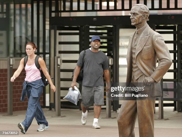 Ford Motor Company employees leave the Ford Dearborn Truck Assembly Plant at the end of their shift under the gaze of a statue of Ford founder Henry...