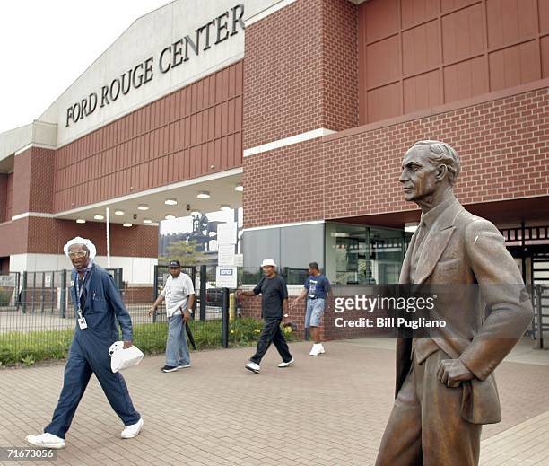 Ford Motor Company employees leave the Ford Dearborn Truck Assembly Plant at the end of their shift under the gaze of a statue of Ford founder Henry...