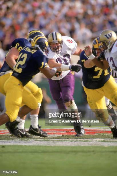 Steve Emtman of the Washington Huskies drives through the Michigan Wolverines defensive line at the 1991 Rose Bowl on January 1, 1992 in Pasadena,...