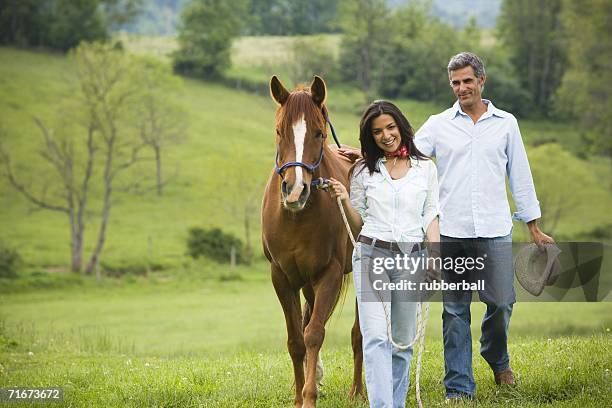 man and a woman walking with a horse - blaze pattern animal marking stock pictures, royalty-free photos & images