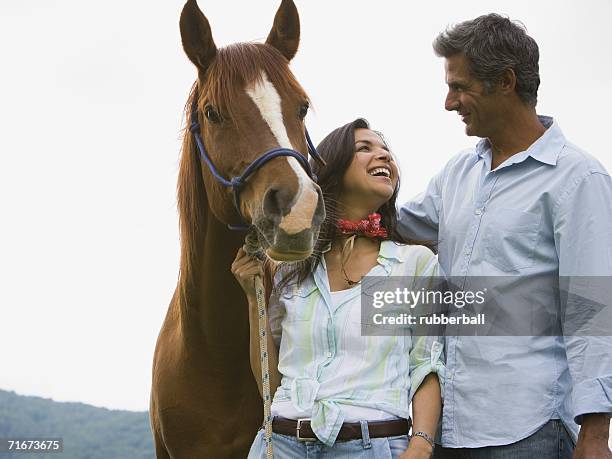 woman holding the reins of a horse with a man beside her - blaze pattern animal marking stock pictures, royalty-free photos & images