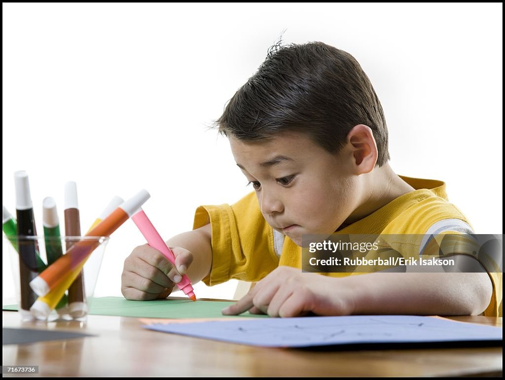 Close-up of a boy drawing with a felt tip pen