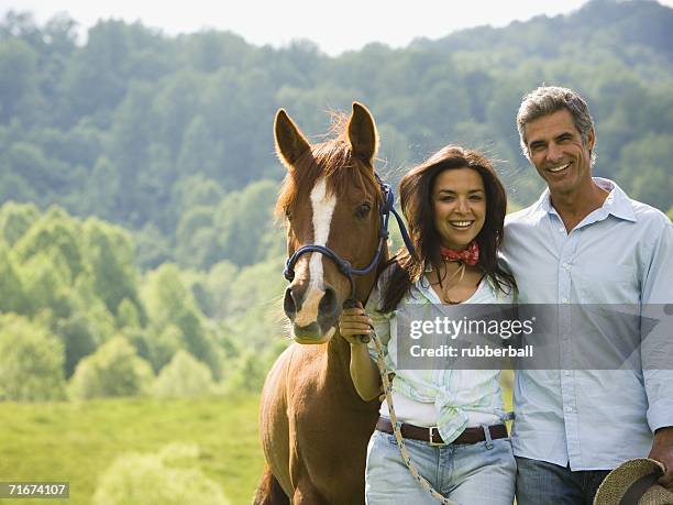 portrait of a man and a  woman standing with a horse - gateado imagens e fotografias de stock