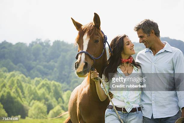 a man and a woman standing with a horse - gateado imagens e fotografias de stock