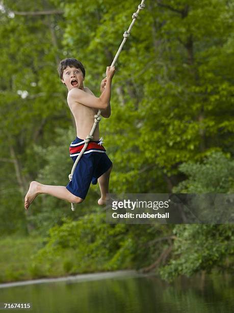 portrait of a boy swinging on a rope - altalena di corda foto e immagini stock