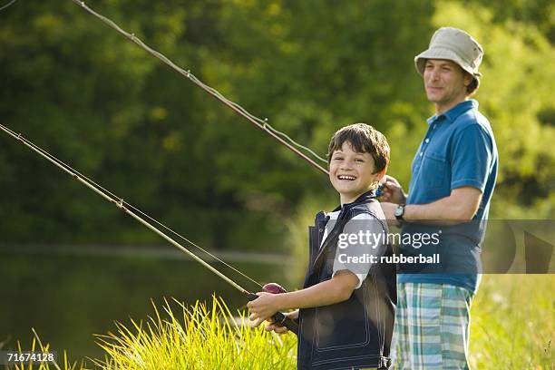 man and his son fishing - tee reel stock pictures, royalty-free photos & images