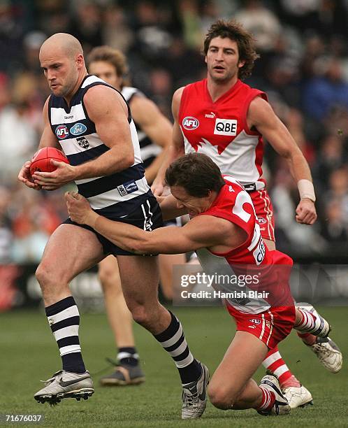 Paul Chapman for Geelong is tackled by Luke Ablett for Sydney during the round 20 AFL match between the Geelong Cats and the Sydney Swans at Skilled...