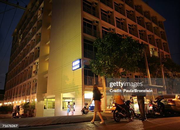 People walk in front of of the Blooms apartment building where John Mark Karr lived August 18, 2006 in Bangkok, Thailand. Karr is under arrest at the...
