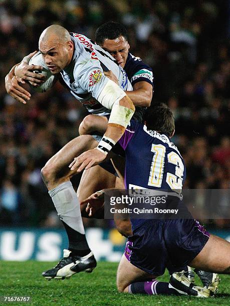 Awen Guttenbeil of the Warriors is tackled by Dallas Johnson and David Kidwell of the Storm during the round 24 NRL match between the Melbourne Storm...