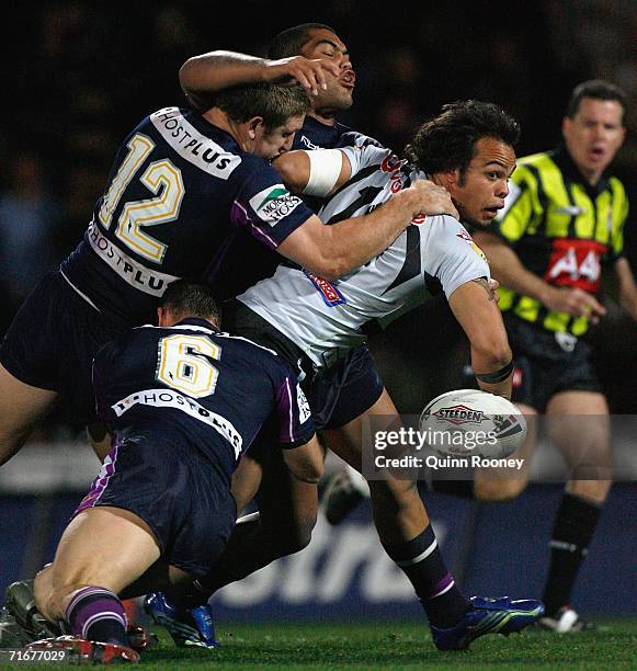 Sam Rapira of the Warriors is tackled by Ryan Hoffman and Scott Hill of the Storm during the round 24 NRL match between the Melbourne Storm and the...
