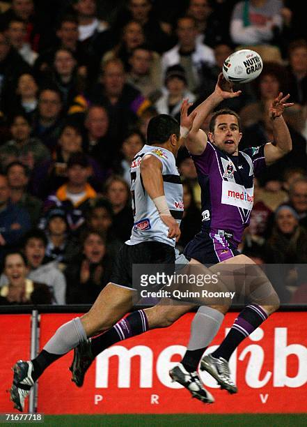 Steve Turner of the Storm passes over the top of Jerome Ropati of the Warriors during the round 24 NRL match between the Melbourne Storm and the...