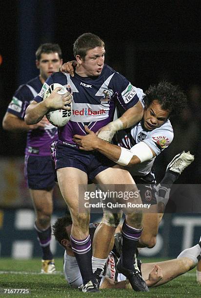 Adam Blair of the Storm is tackled by Sam Rapira of the Warriors during the round 24 NRL match between the Melbourne Storm and the Warriors at...