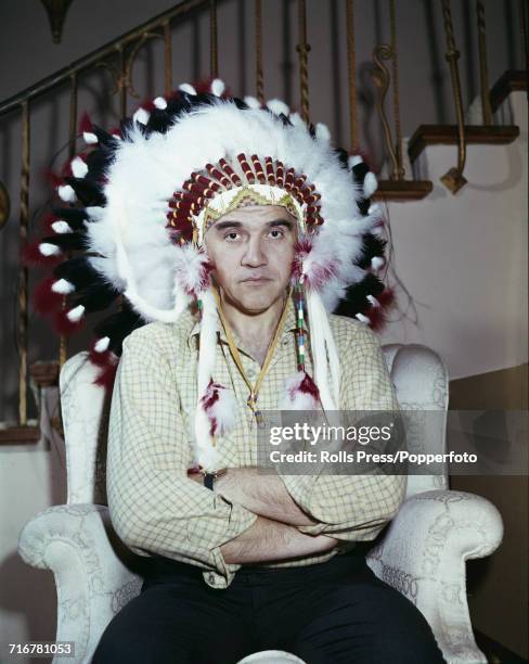 Canadian actor Lorne Greene who plays the character of Ben Cartwright in the television series Bonanza, posed wearing a native American feather...