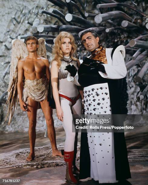 View of a scene from the science fiction film Barbarella with Irish actor Milo O'Shea in character as Durand Durand directing Jane Fonda as...