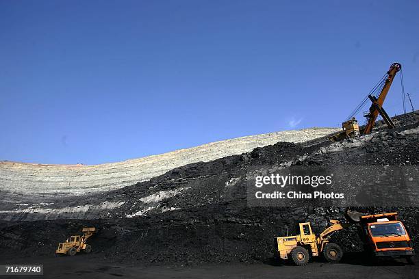 Front-end bucket loader moves coals into a coal hauling truck in an open pit coal mine on August 19, 2006 in Chifeng of Inner Mongolia Autonomous...