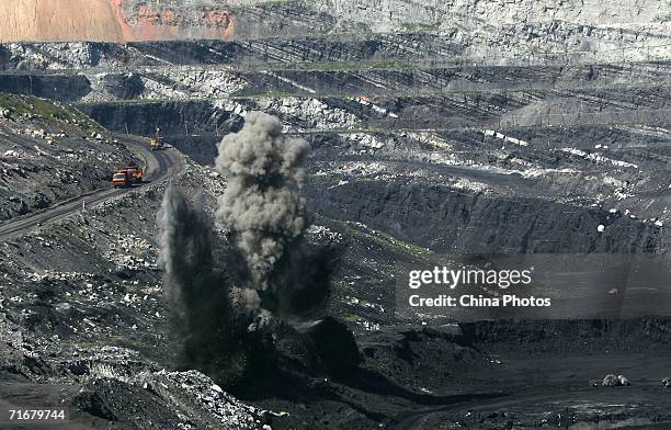 Smokes rise from coal seams after a blasting in an open pit coal mine on August 19, 2006 in Chifeng of Inner Mongolia Autonomous Region, China....