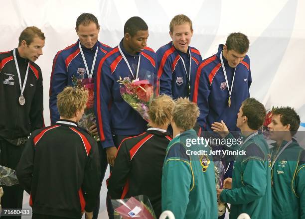 Jason Lezak, Cullen Jones, Neil Walker and Michael Phelps of the USA are congratulated by swimmers from the Austrailian and Canadian 4 x 100 teams...