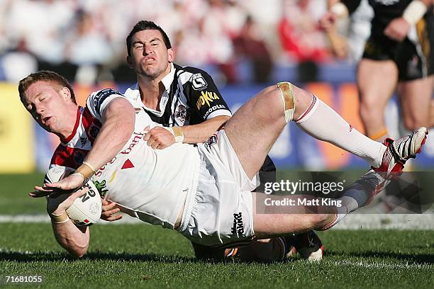 Ben Creagh of the Dragons is tackled by Shannon McDonnell of the Tigers during the round 24 NRL match between the St. George Illawarra Dragons and...