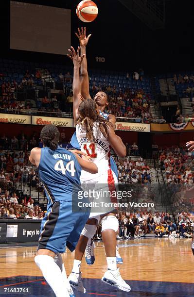 DeLisha Milton-Jones of the Washington Mystics shoots against Taj McWilliams-Franklin of the Connecticut Sun in game two of the Eastern Conference...