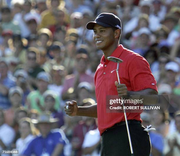 Medinah, UNITED STATES: Tiger Woods of the United States celebrates after sinking the winning putt on the 18th hole 20 August 2006 during the final...