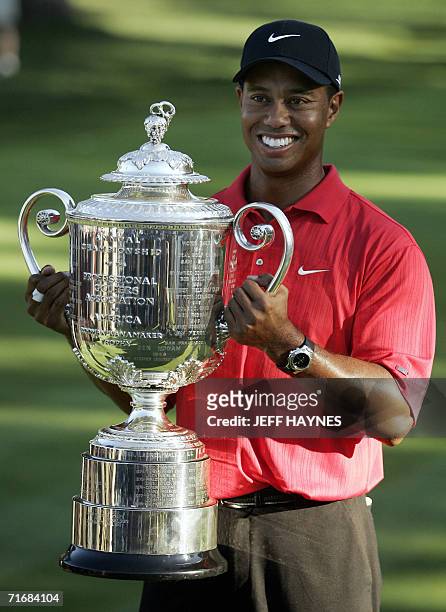 Medinah, UNITED STATES: Tiger Woods of the US poses with the Wanamaker Trophy 20 August 2006 after winning the 88th PGA golf championship at the...