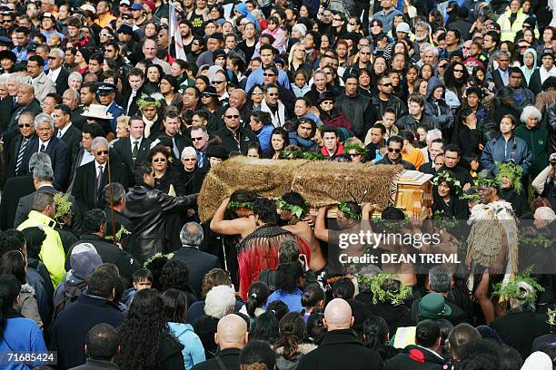 People watch as Maori Warriors carry the coffin of Queen Te Arikinui Dame Te Atairangikaahu from the Waikato River toward the top of Mount Taupiri to...