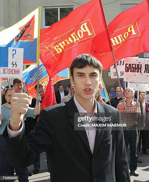 Moscow, RUSSIAN FEDERATION: A member of the nationalist Rodina Party shouts as his comrades hold flags and posters at a demonstration in front of the...