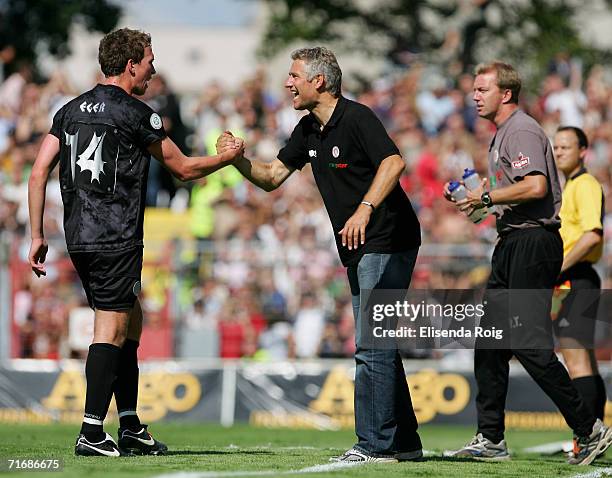 Coach Andreas Bergmann of Pauli shakes hands with Marcel Eger of Pauli during the Third League match between FC St.Pauli and Werder Bremen II at the...