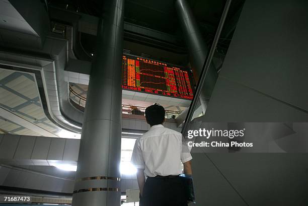 Man looks at an electronic board displaying stock index at a securities company August 21, 2006 in Shenzhen of Guangdong Province, China. Chinese...