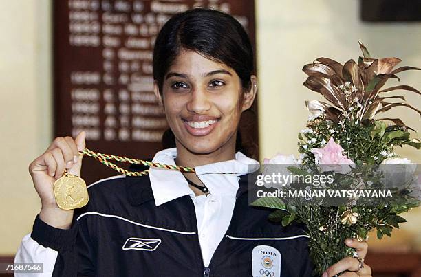 Indian squash player Joshanna Chinappa poses with her gold medal after defeating compatriot Deepika Pallikal in their women's Squash individual final...