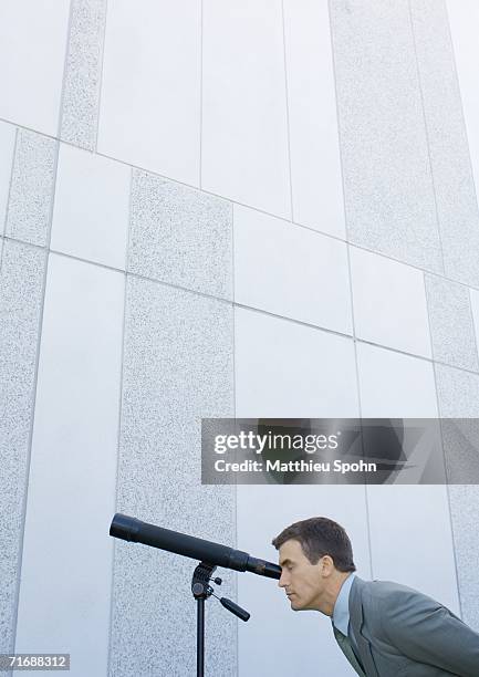 businessman looking through telescope - vouyer stock pictures, royalty-free photos & images