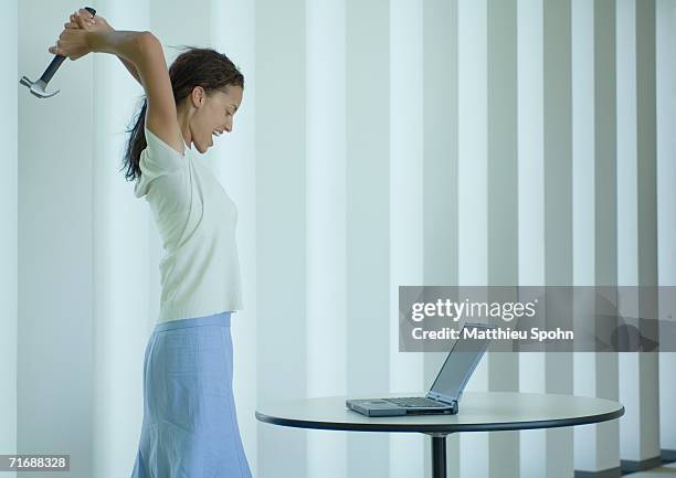 woman shouting and swinging hammer at laptop - computer rage stock pictures, royalty-free photos & images