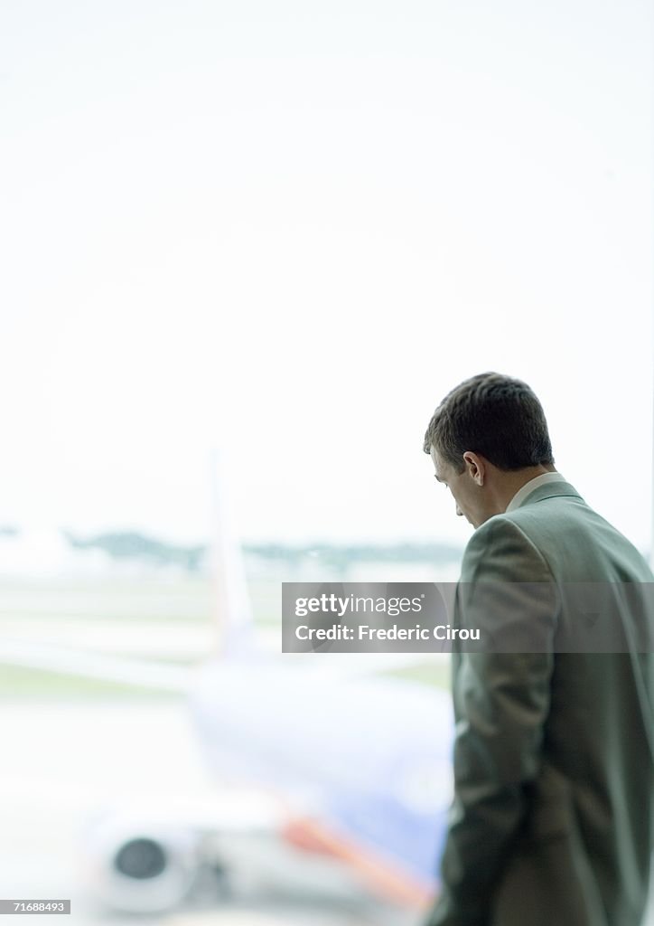 Man standing by window in airport