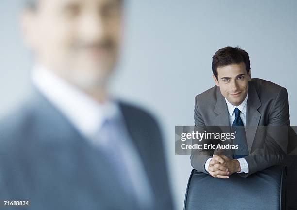 businessman leaning on back of chair, focus on background - leaning on elbows stock pictures, royalty-free photos & images