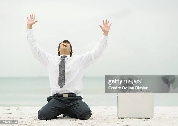 businessman down on knees, shouting, on beach - rogar fotografías e imágenes de stock